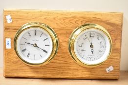 A 20th-century gilt metal wall-mounted clock and barometer set on an oak-stained wooden board, 42cm,