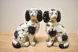A pair of reproduction Victorian Staffordshire pottery style mantel dogs, featuring hand painted bl