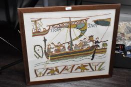 A contemporary framed embroidery reproduction of a section of the Bayeux Tapestry, a tapestry that