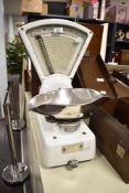 A 20th-century Swift Scale Company white enamelled metal grocers scale, featuring a large analogue