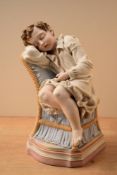A polychrome Bisque figure, depicting a seated child asleep on serpentine parcel gilt stepped bases,