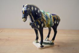 A ceramic Tang style Horse study, having a sancai mottled blue, green and brown glaze, raised on a