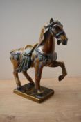 A large ceramic Tang style Horse study, having a mottled orange and brown glaze, raised on a