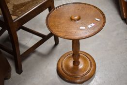 A curious golden oak occasional table of bobbin reel form with platform base, diameter approx. 33cm,
