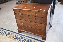 A 19th Century Georgian oak chest of four long drawers, having brass drop handles and bracket