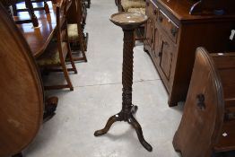 An early 20th Century mahogany torchere having circular top with twist column and triple splay legs,
