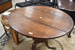 A 19th Century oak pedestal table having circular snap top on turned column and triple splay legs,