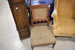A Victorian mahogany framed low seat nursing chair, stamped Gillow to leg
