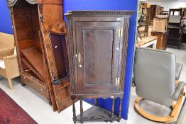 A Georgian oak corner cupboard on turned supports with shelf under, height approx. 149cm, width