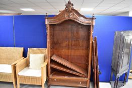 A late 19th or early 20th Century mahogany armoire style bookcase having foliate applique decoration