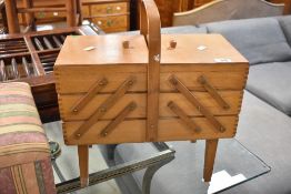A vintage cantilever sewing box on legs and an upholstered ottoman style foot stool
