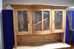A late 19th or early 20th century pine kitchen or similar cabinet , having glazed top with bow