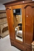 A late 19th or early 20th Century mirror door wardrobe