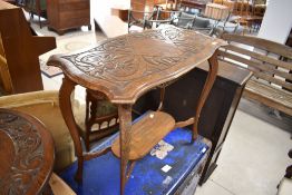 An early to mid 20th Century carved oak occasional table having oval undertier, width approx. 83cm
