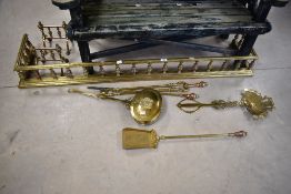 A 19th Century brass and copper fire fender, similar fire dogs and selection of tools