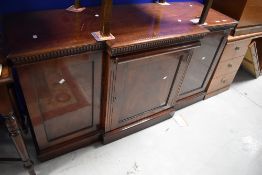 A nice quality reproduction breakfront sideboard having central pull out scroll design skiver top