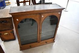 A Victorian mahogany bookcase top with wall mountings, having arched glazed section and single