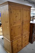 A modern pine double wardrobe having six drawer base, dimensions approx. W123 H195 D59cm