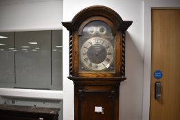 An early 20th Century oak long cased clock having multiple chimes, with brass and silvered arch dial