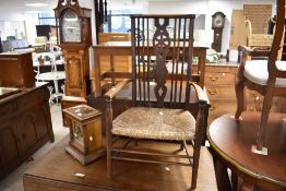 A traditional (late 19th or early 20th Century) rush seated armchair having spindle and wheelback
