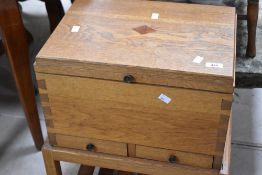 A golden oak Arts & Crafts style sewing or work box on stand, overall dimensions approx. H66 W49