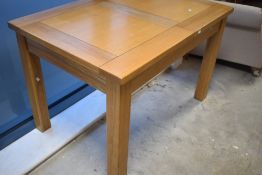 A modern golden oak extending dining table and set of four leatherette dining chairs. Table