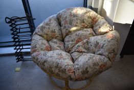 A vintage 'papasan' chair of circular form with floral cushion