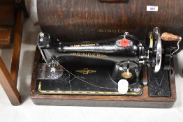 A vintage Singer sewing machine in oak ply dome top case