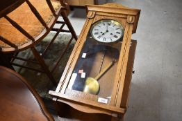 An early 20th century golden oak cased wall clock having silvered Roman numeral dial, height approx.