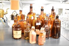 A selection of Victorian apothecary amber-coloured glass bottles, including poison, elixir and