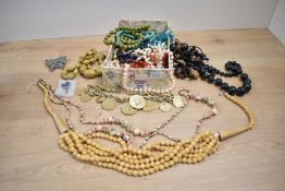 An assortment of costume jewellery, including faux pearls, beaded jewellery, brooches and shell