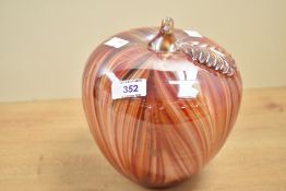 A large decorative contemporary studio art glass apple, featuring a vibrant pulled feather pattern