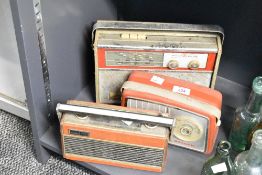 Three 20th-century red-coloured radios, to include a Roberts Rambler transistor radio, a Dansette