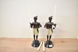 Two 20th-century figuritive cast patinated metal candle holders, featuring two 'Nubian'-style