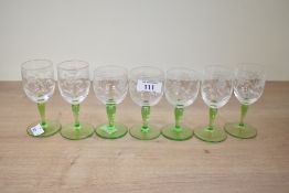 A quantity of seven mid 20th-century green stem sherry glasses, featuring etched floral decoration