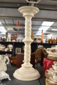A tall contemporary turned wood column-formed plant stand, having been painted white/cream,