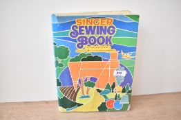 A vintage hardback Singer Sewing Book, featuring a comprehensive guide to sewing techniques and