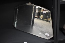 A 20th-century Art-Deco mirror, having a decorated gilded top and a framless bevelled mirror, 56cm