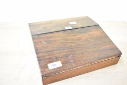 A small 19th/20th-century wooden writing slope of interesting form, having a deep green velvet