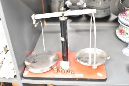 A 20th-century metal scale, having various brass weights, 32cm.