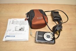 A Canon Powershot A3150IS camera with booklets and disc