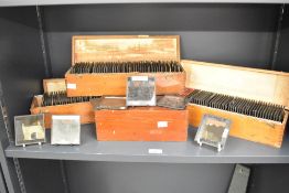 A large quantity of 19th-century Magic Lantern glass image slides in a selection of wooden cases,