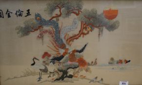 A 20th century Chinese silk embroidery depicting vibrant birds beneath a tree and body of water,