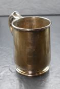 A George V silver tankard, of traditional form, having a moulded rim and scroll handle with bead