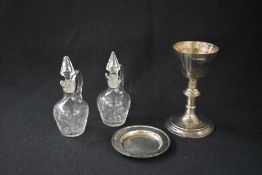 A George V boxed silver communion set, comprising as chalice, paten and two glass decanters, of