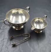 A Edwardian silver sugar and cream, of circular form having moulded rims and c-curve handles with '