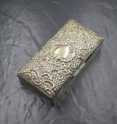An Edwardian silver cigarette box, of hinged rectangular form having ornate diaper and scroll