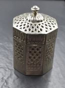 An Eastern white metal Betel nut holder, of octagonal form having a moulded finial top with