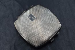 A George VI silver mounted powder compact, of hinged square form having engine turned decoration and