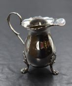 An Elizabeth II silver cream jug, having Chippendale style rim, generous spout opposed by a scroll